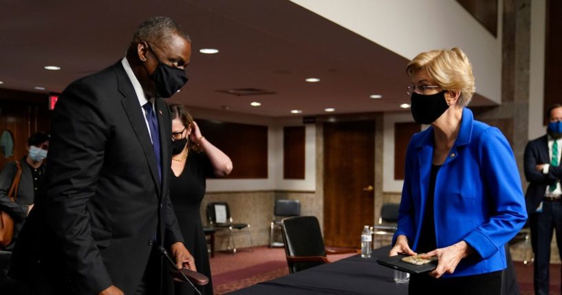 Elizabeth Warren (D-MA) (R) speaks to U.S. Secretary of Defense Lloyd Austin during a break in the Senate Armed Services Committee hearing on the conclusion of military operations in Afghanistan and plans for future counterterrorism operations on Capitol Hill on September 28, 2021 in Washington, DC.