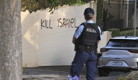 A police officer stands near where anti-Israel graffiti is painted on a wall in Sydney, Australia, on Dec. 11.