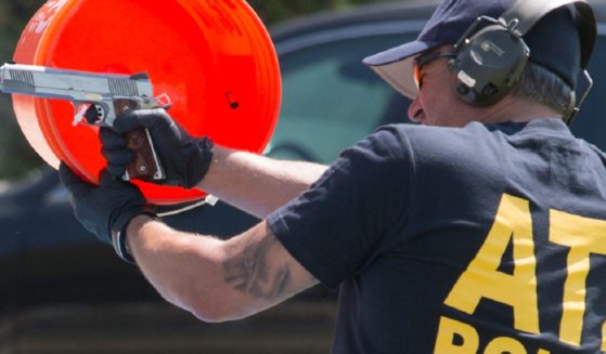 An ATF agent is pictured in a 2017 file photo using a bucket to catch a shell casing from a handgun at a law enforcement facility in Glendale, California.