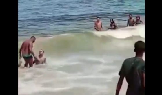 Beachgoers in Rio de Janeiro, Brazil, confront a naked man found at the beach.