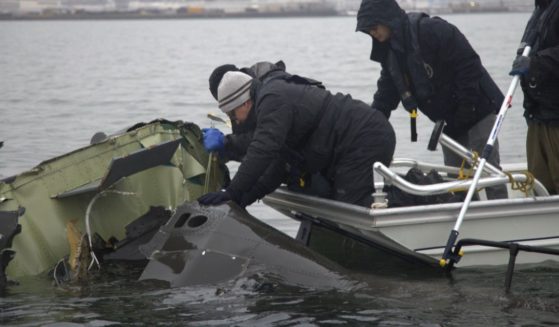 National Transportation Safety Board investigators along with members of the salvage crew recover wreckage from the Bombardier CRJ700 and Sikorsky UH-60 Black Hawk mid-air collision in the Potomac River in Arlington, Virginia, on Sunday.