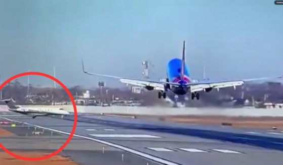 The Southwest pilot aborted the landing when a small jet, left, rolled into its path.