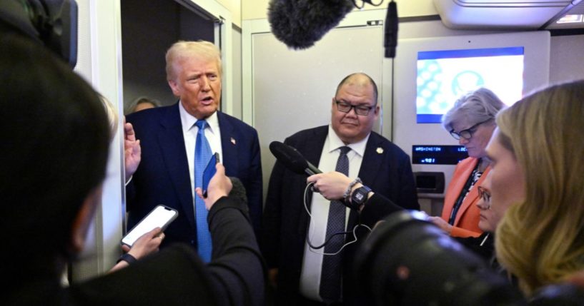 President Donald Trump, left, speaks to reporters aboard Air Force One on route from Miami, Florida, to the White House in Washington, D.C., on Wednesday.