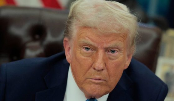 President Donald Trump talks to reporters after signing an executive order in the Oval Office of the White House in Washington, D.C., on Friday.