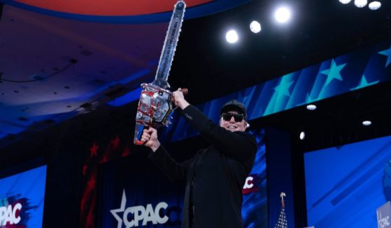 Elon Musk holds a chainsaw as he arrives to speak at the Conservative Political Action Conference in Oxon Hill, Maryland, on Feb. 20.