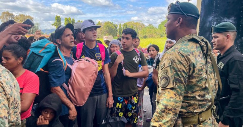 Migrants talk to Panamanian National Border Service members as they try to cross the border between Panama and Costa Rica while trying to return to Venezuela on Tuesday.