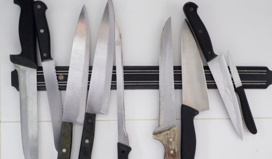 A set of kitchen knives are displayed on a magnetic holder.