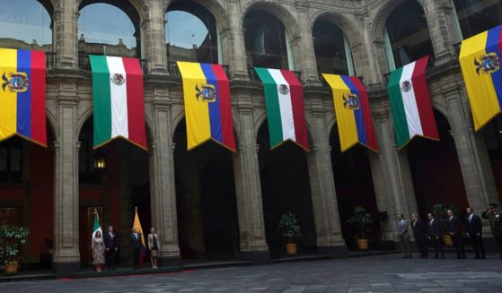 Mexican and Ecuadorean flags hang at the National Palace during a government ceremony in Mexico City on Nov. 24, 2022.