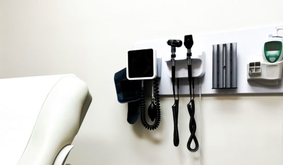 Medical equipment sits mounted on the wall inside a doctor's office.