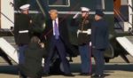 President Donald Trump interacts with a United States Marine after exiting Marine One.