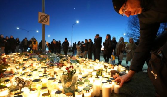 People take part in a vigil Thursday near the scene of a mass shooting that took place the day before at an adult education center on the outskirts of Orebro, Sweden. Eleven people were killed and at least six wounded in the attack.