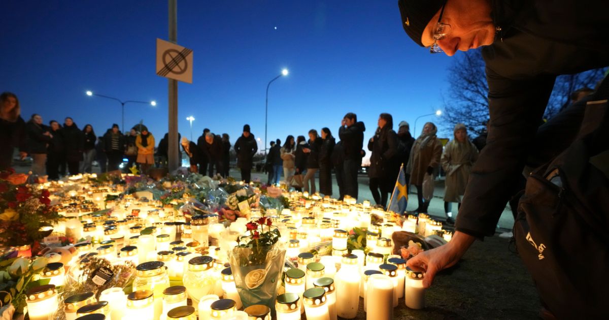 People take part in a vigil Thursday near the scene of a mass shooting that took place the day before at an adult education center on the outskirts of Orebro, Sweden. Eleven people were killed and at least six wounded in the attack.