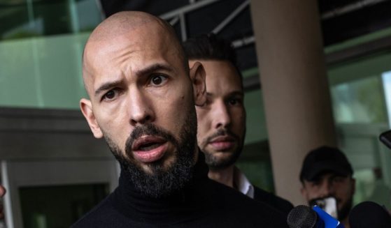 Andrew Tate, left, and his brother Tristan Tate arrive at Florida's Fort Lauderdale-Hollywood International Airport Thursday after a travel ban on them was lifted. The influencer brothers were arrested in late 2022 and face human trafficking charges. Authorities allege that they participated in a criminal ring that lured women to Romania, where they were sexually exploited.