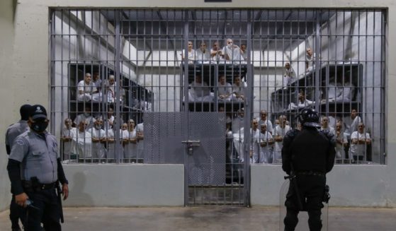 Police officers wearing riot gear stand on patrol inside a cell at CECOT in Tecoluca, El Salvador, on Feb. 6, 2024.