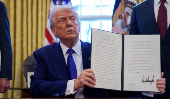 President Donald Trump signs an executive order withholding federal funding from schools and universities that impose a COVID-19 vaccine mandate in the Oval Office at the White House on Feb. 14, 2025, in Washington, D.C.