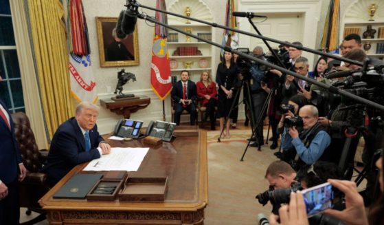 President Donald Trump, flanked by Interior Secretary Doug Burgum, left, takes questions from reporters in the Oval Office in a file photo from Jan. 31.