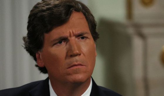 Tucker Carlson listens during an interview with Russia's President Vladimir Putin at the Kremlin in Moscow on Feb. 6, 2024.