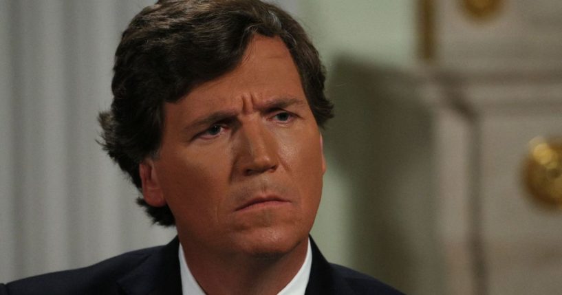 Tucker Carlson listens during an interview with Russia's President Vladimir Putin at the Kremlin in Moscow on Feb. 6, 2024.