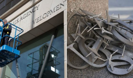 A worker, left, removes the signage from the United States Agency for International Development on the agency's headquarters in Washington, D.C. on Feb.7. The discarded letters are seen at right. Google Trends noted an alarming uptick in troubling search terms in the D.C. area after the move.