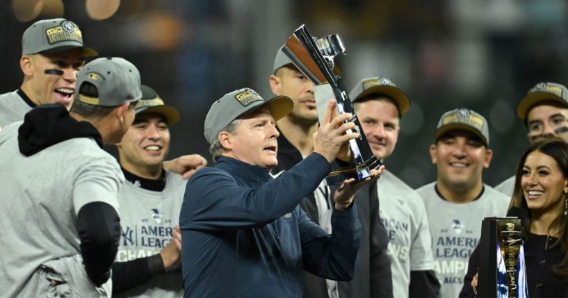 New York Yankees Chairman Hal Steinbrenner hoists the trophy after the Yankees beat the Cleveland Guardians in Game Five of the American League Championship Series at Progressive Field on Oct. 19, 2024, in Cleveland, Ohio.