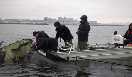 National Transporation Safety Board investigators and salvage crew workers recover wreckage Sunday from last week's midair collision between a passenger jet and an Army Black Hawk helicopter over the Potomac River.