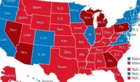 A map of the United States with Democratic states in blue, Republican states in Red, and seven swing states in magenta.