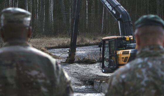 U.S. Army soldiers from the 1st Armored Brigade Combat Team, 3rd Infantry Division, along with Lithuanian Army and emergency services personnel, discuss their plan to recover four U.S. soldiers in a U.S. Army M88 Hercules submerged under several meters of water in a swamp near a training area outside Pabadre, Lithuania, on Thursday.