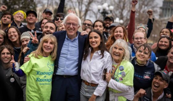 Rep. Alexandria Ocasio Cortez, a New York Democrat, and Senator Bernie Sanders, an independent from Vermont, pose for photographs during a rally Friday in Denver, Colorado. Sanders and AOC boasted of what appeared to be impressive turnouts, but a data expert raised questions about the background and motivations of a large percentage of those attendees.