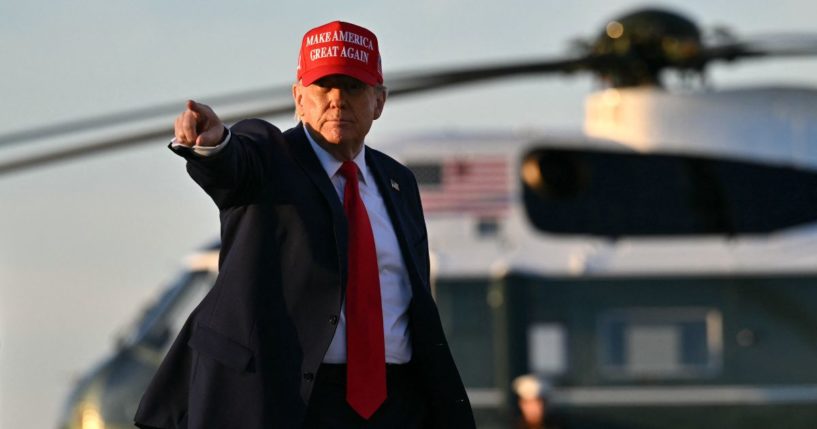 President Donald Trump points to a television crew as he walks to board Air Force One as he departs Joint Base Andrews in Maryland on Friday.