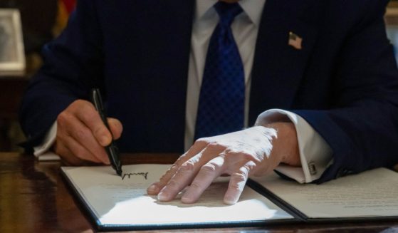 President Donald Trump signs an executive order on halting federal funds for schools and universities that impose coronavirus vaccine mandates in the Oval Office of the White House in Washington, D.C., on Feb. 14.