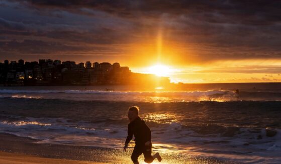 A young boy runs along Bondi beach at sunrise on Oct. 16, 2021, in Sydney, Australia.