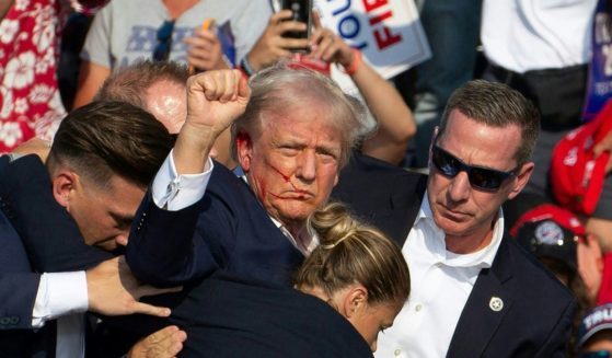 President Donald Trump is seen with blood on his face surrounded by Secret Service agents as he is taken off the stage at a campaign event in Butler, Pennsylvania, on July 13, 2024.