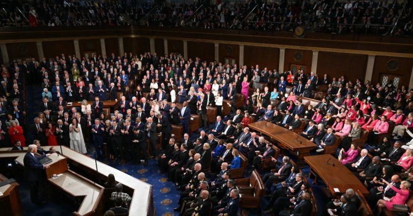 President Donald Trump gives a speech to a joint session of Congress, as Republicans stand and applaud, left, and Democrats jeer and hold up signs, right, in the House chamber of the U.S. Capitol in Washington, D.C., on Tuesday.