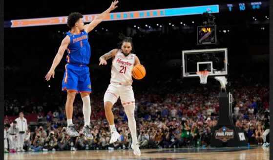 Florida's Walter Clayton Jr. (1) jumps to knock the ball from Houston's Emanuel Sharp (21) during the second half in the national championship at the Final Four of the NCAA college basketball tournament Monday in San Antonio, Texas.