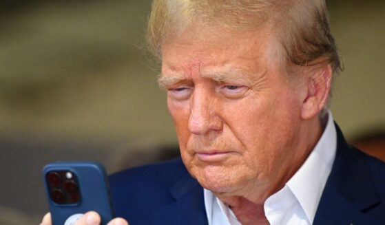 Donald Trump talks on the phone in the McLaren garage prior to the F1 Grand Prix of Miami in Miami, Florida, on May 5, 2024.