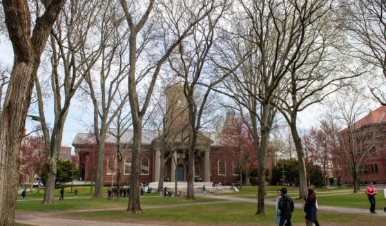 People walk through Harvard Yard on the Harvard University campus in Cambridge, Massachusetts, on Tuesday.
