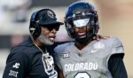 Head coach Deion Sanders, left, of the Colorado Buffaloes celebrates with Shedeur Sanders, right, after a fourth quarter touchdown against the Utah Utes in Boulder, Colorado, on Nov. 16.