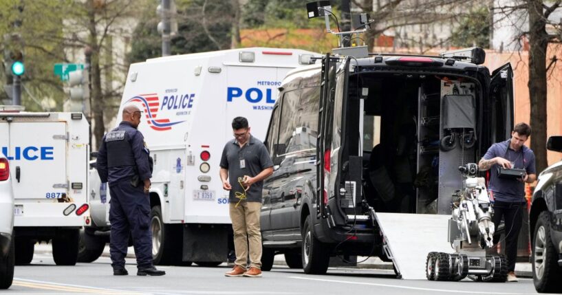 Washington Metropolitan Police and other officials work with a robotic machine in a taped-off area around the White House, Thursday, after early reports of a suspicious package and possible arrest.