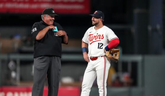 Kyle Farmer of the Minnesota Twins talks with umpire Hunter Wendelstedt on Sept. 9, 2024, at Target Field in Minneapolis, Minnesota.