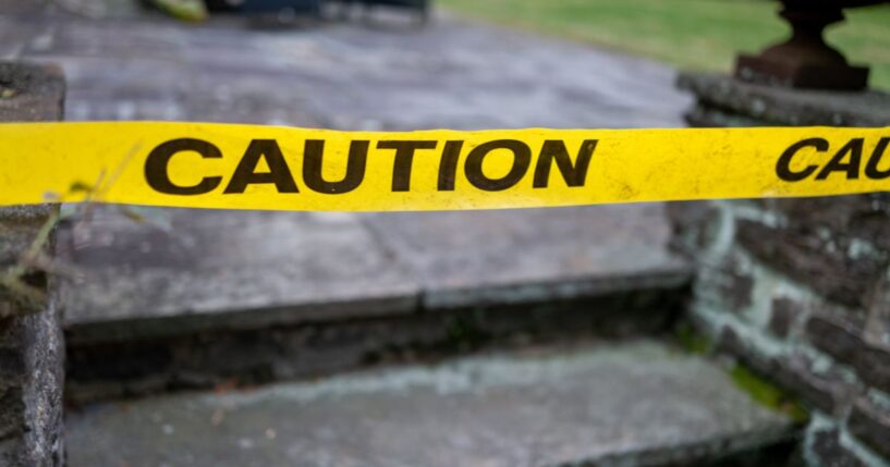 This Getty stock image shows yellow caution tape in front of a crime scene at a home.